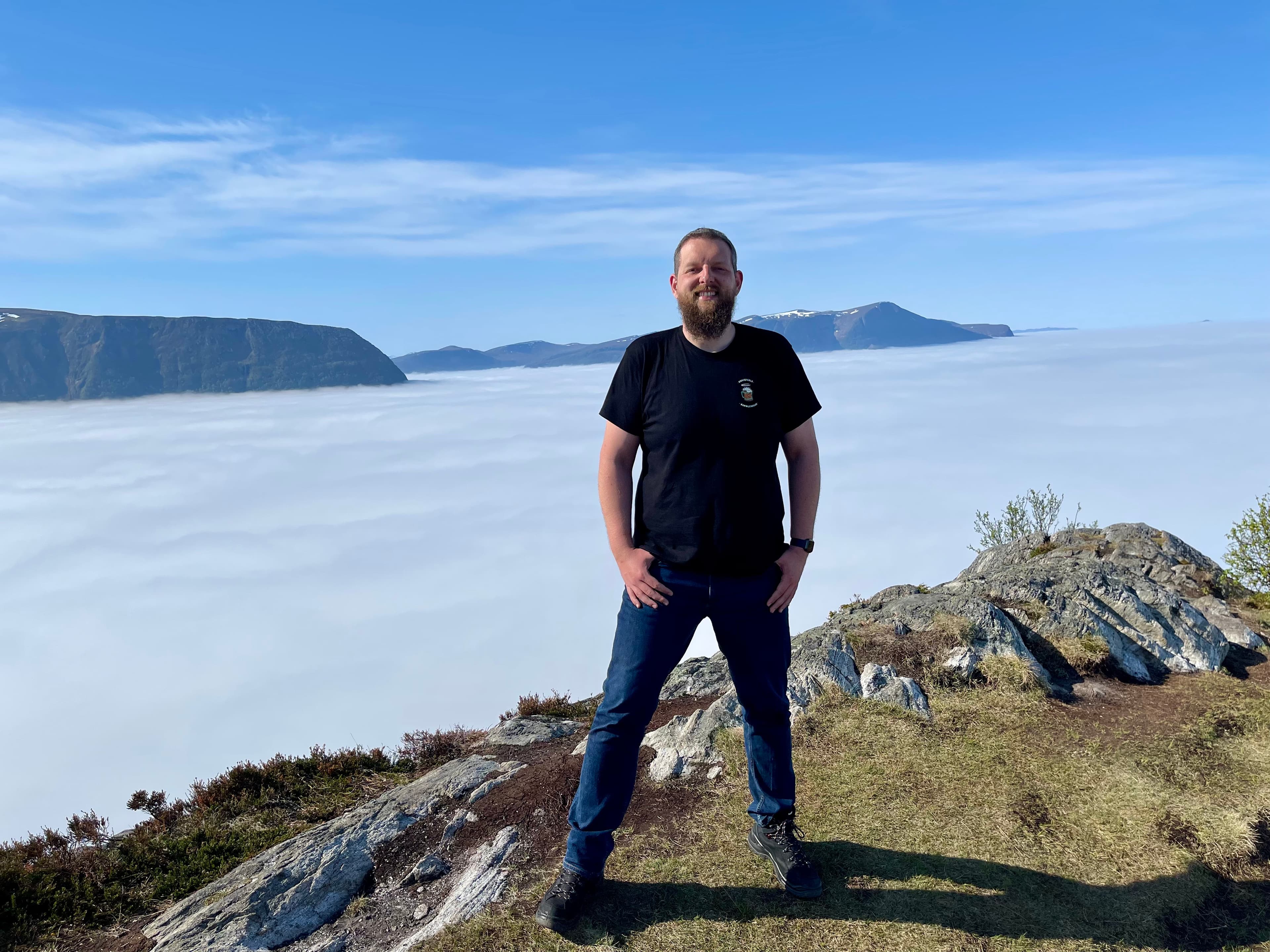 Florian auf einem Berggipfel über den Wolken